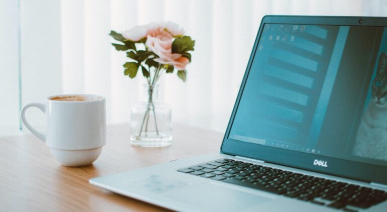 Black and Gray Dell Laptop Beside White Ceramic Mug Flower - Why Choose WordPress